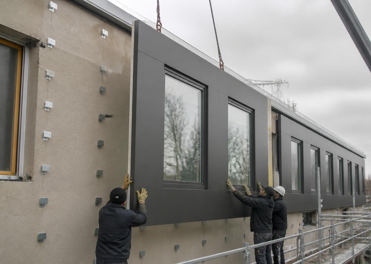 Zeilenbau mit wiederkehrendem Raster wird mit vorgefertigten Fassadenmodulen saniert